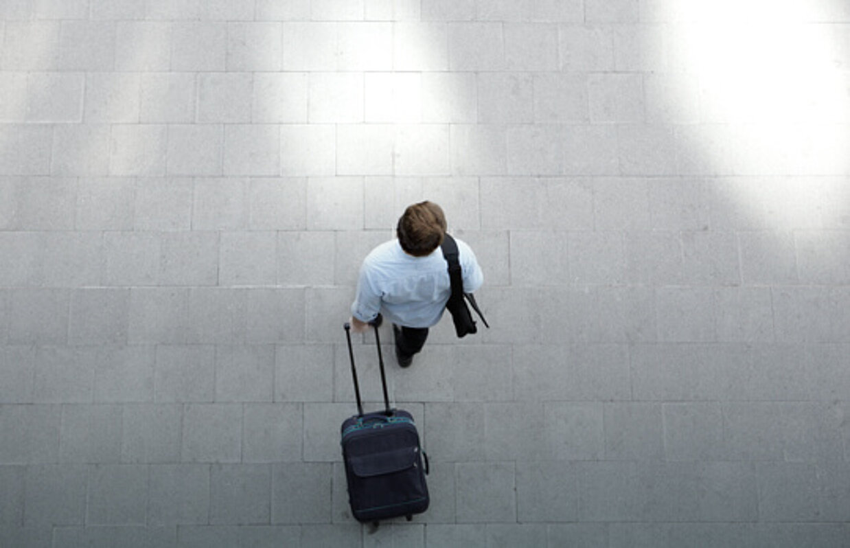 Young man walking with luggage at station