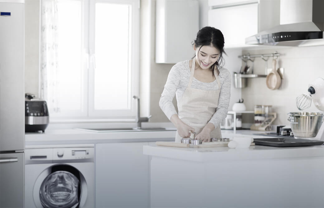 Smiling woman cooking in a modern kitchen.