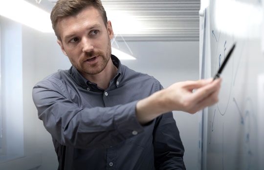 Young man in front of a whiteboard